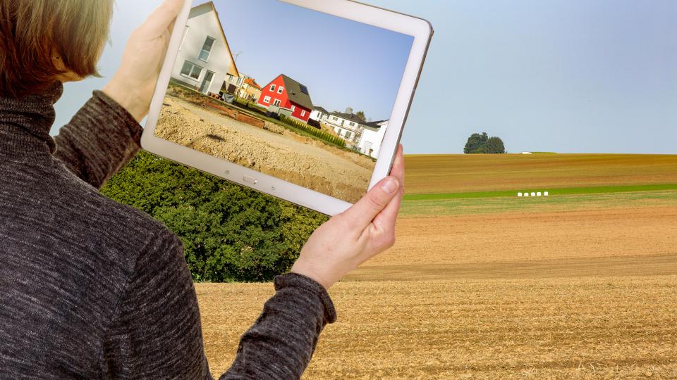 Tablet-PC visualisiert eine Wohnsiedlung im Außenbereich